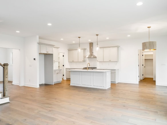 Bright, spacious kitchen with white cabinets, island, and hardwood floors.