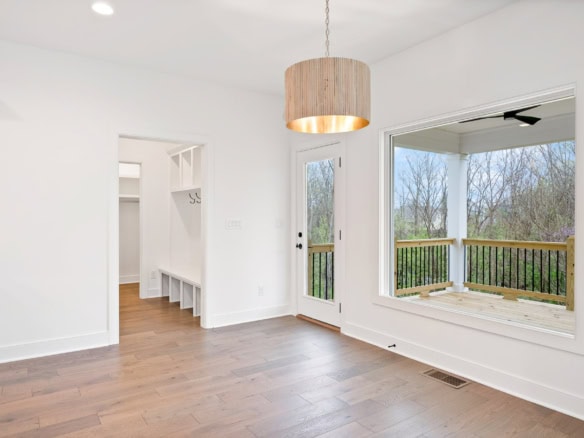Bright living space with large windows, balcony, and hardwood floors.