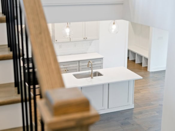 Modern kitchen with white cabinets, island, and pendant lighting.