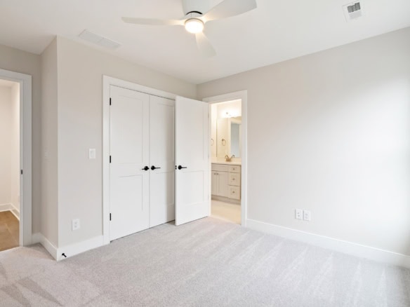 Bright, modern bedroom with white walls and closet doors.