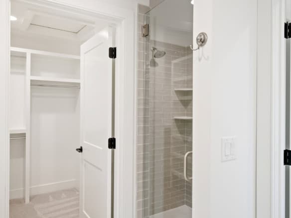 Modern bathroom with walk-in shower and built-in shelves.