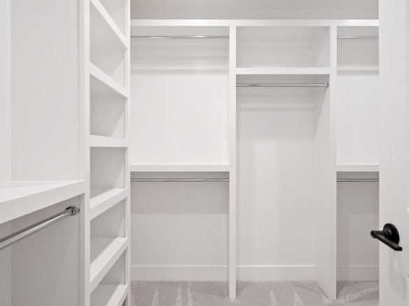 Bright, organized walk-in closet with shelving and hanging space.