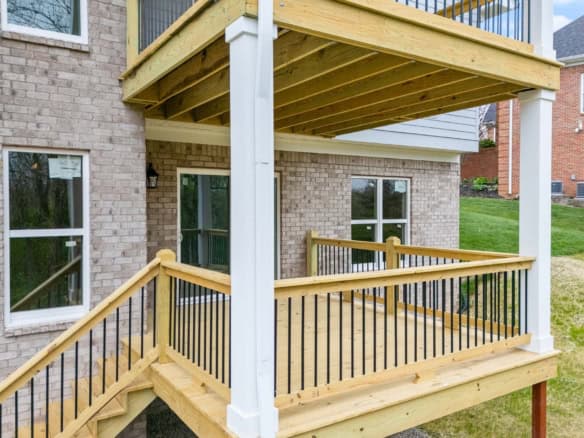 New wooden deck with railing at the back of a brick house on Hypoint Ridge Rd.