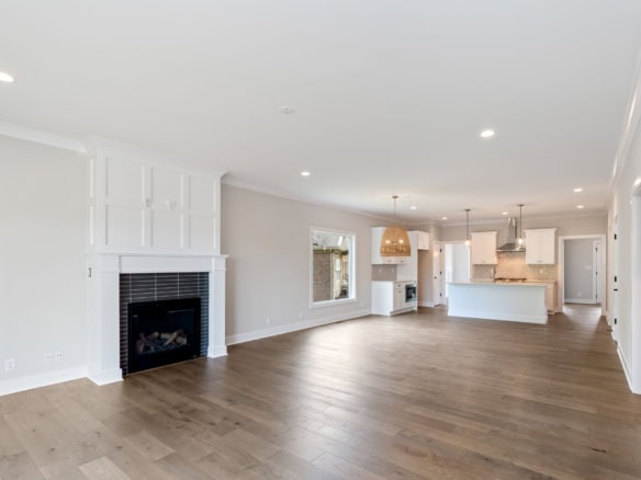 A spacious, bright living area with a modern kitchen, hardwood floors, and large windows.