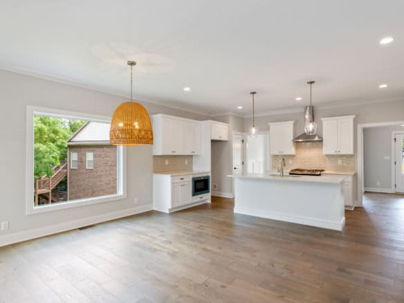 Bright, spacious kitchen with white cabinets and stainless steel appliances.