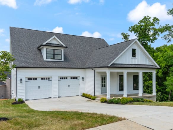 Beautiful new construction home with a spacious front porch and attached garage.