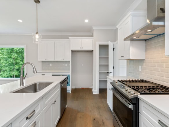 Bright, modern kitchen with white cabinets and oakmont surroundings.