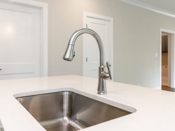 Contemporary kitchen sink with stainless steel faucet in a new home.