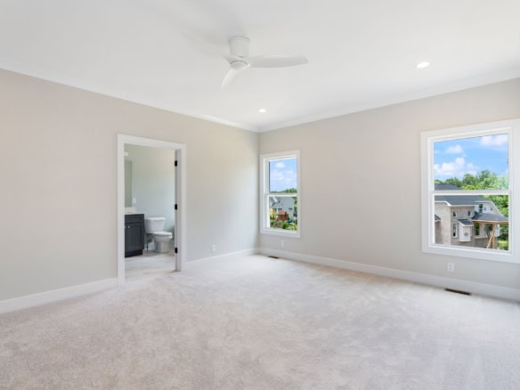 Bright, spacious bedroom featuring large windows and neutral walls.