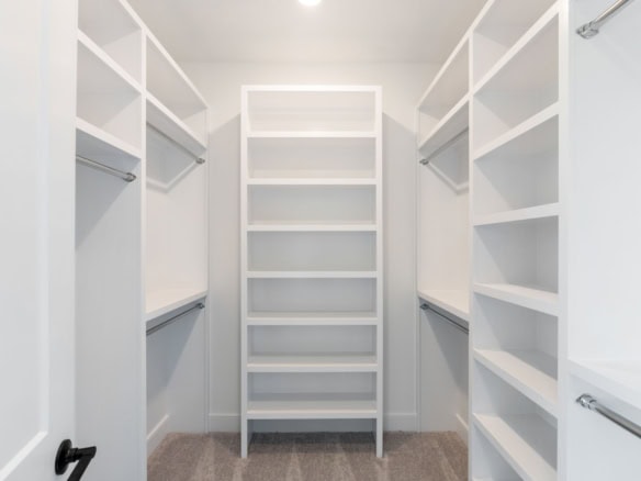 Spacious walk-in closet featuring white shelving and hanging rods at 6603 Oakmont Cir.