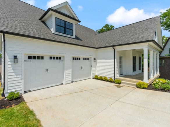New construction home with white siding, double garage, and front porch.
