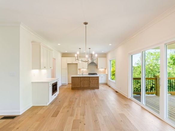 Interior view of a modern kitchen and living space with large windows.