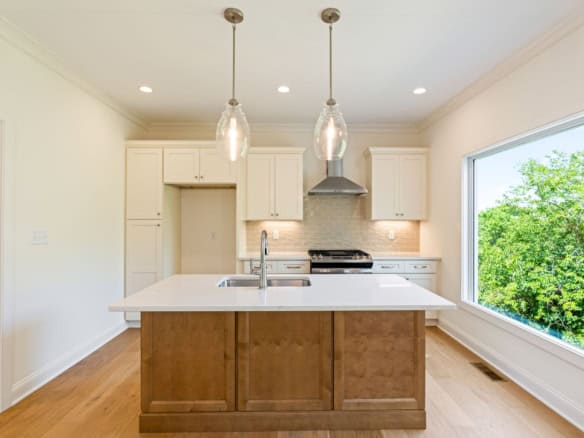 Bright kitchen featuring white cabinetry, island, and ample natural light.