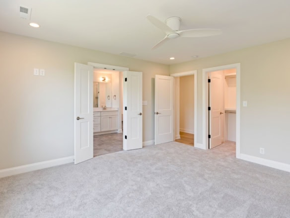Bright bedroom with open closet doors and attached bathroom.