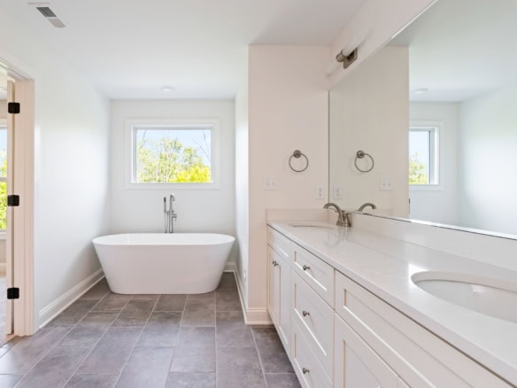 Modern bathroom with bathtub and double vanity.
