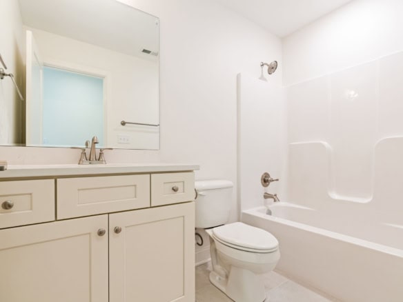 Bright, clean bathroom featuring a white vanity, bathtub, and modern fixtures.