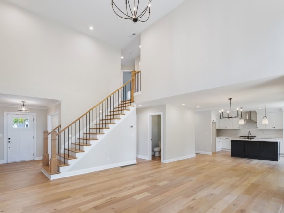 Bright, spacious open-concept living area with high ceilings and hardwood floors.
