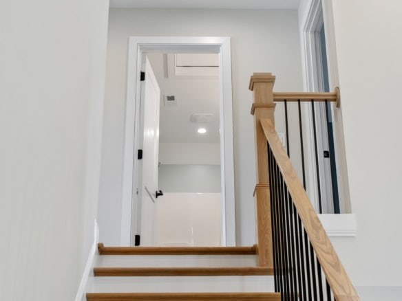 Bright, clean staircase with wooden steps and white walls at 6713 Hypoint Ridge Rd.
