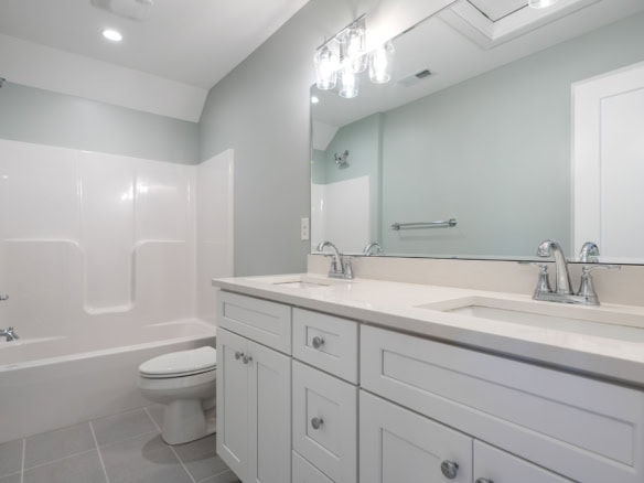 Bathroom with double sink, mirror, and bathtub.