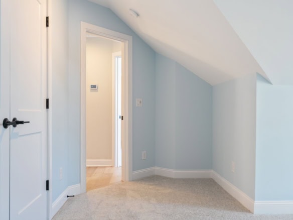 Bright, modern attic bedroom with sloped ceiling.