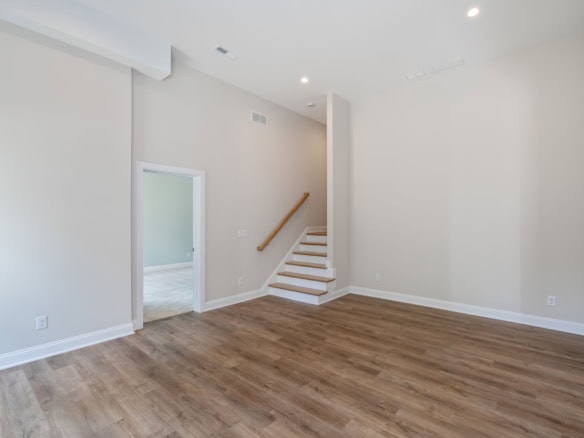 Bright, spacious living room with white walls and hardwood floors.