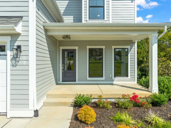 Front porch of a modern house with steps and landscaped garden.