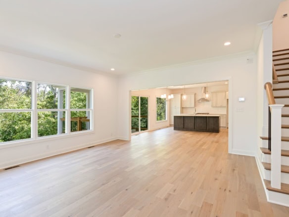 Bright living room with large windows and open kitchen layout.