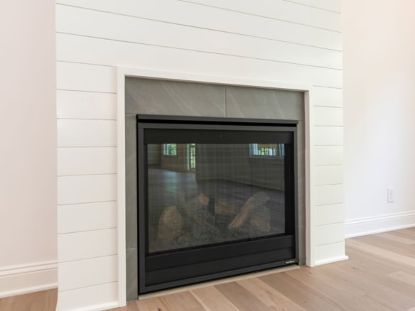 Fireplace with black frame and stone surround in a contemporary living room.