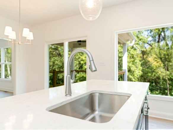 Bright kitchen featuring a stainless steel sink and scenic outdoor views.