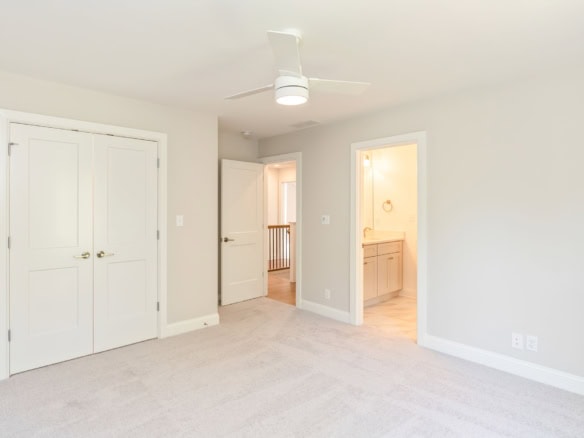 Bright, clean interior room with closet and doorway to bathroom.
