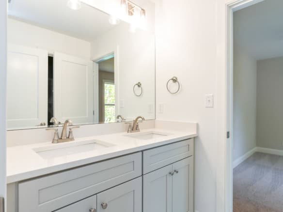 Bathroom vanity with double sinks and large mirror in a new home.