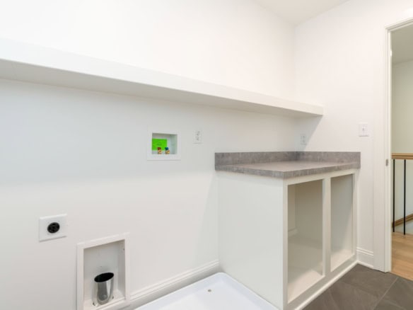 Interior laundry space with countertop and utility connections.