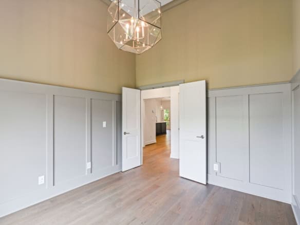 Interior view showcasing wainscoting and a doorway in a residential space.