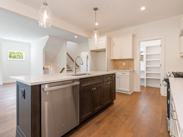 Bright, spacious kitchen featuring white cabinetry, a central island, and stainless steel appliances.