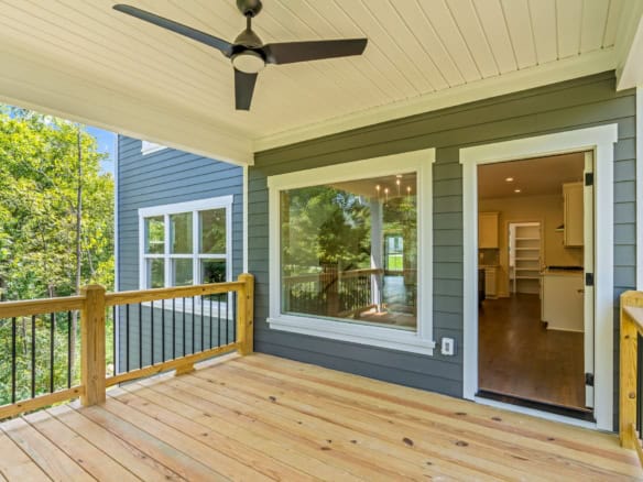 Outdoor deck with ceiling fan and view of the house.