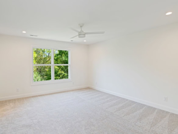 Bright, spacious empty room with large window and white walls.