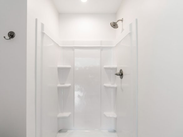 Modern white shower with built-in shelves.