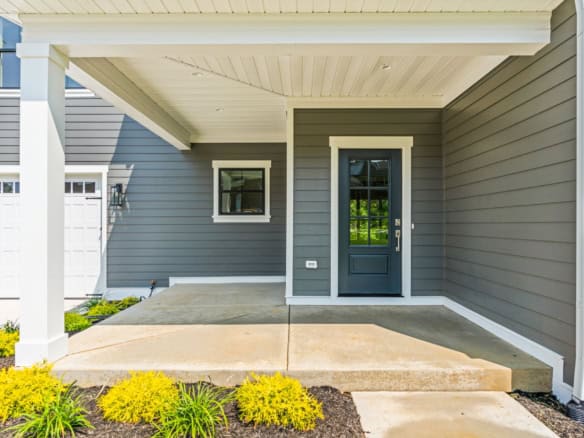 New modern blue house entrance with covered porch and front steps.
