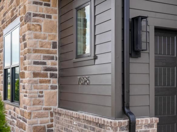 Image of a contemporary house with stone accents and gray siding.