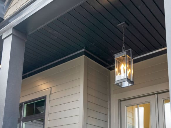 A close-up of a porch light fixture on a modern house exterior at 7395 Edith Way.