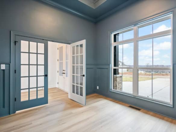 Bright interior space with large window and French doors in a new home at 7395 Edith Way.
