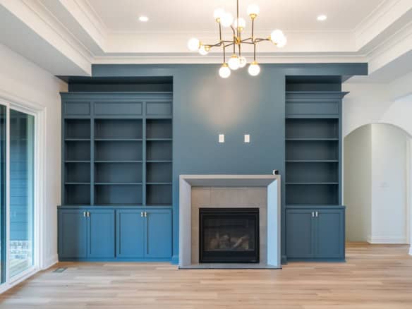 Modern living room featuring custom blue bookshelves and a fireplace.