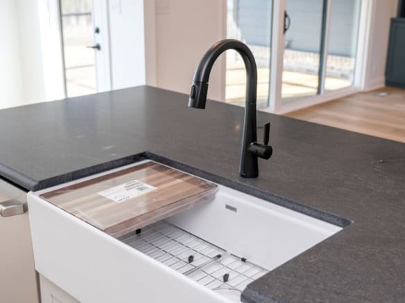 Modern kitchen sink with black faucet and countertop for 7395 Edith Way.