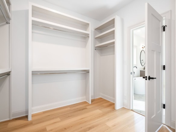Walk-in closet with built-in shelves and ample storage space.