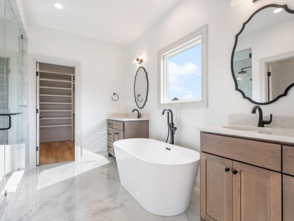 Bright, modern bathroom featuring a freestanding bathtub, double vanity, and walk-in shower.