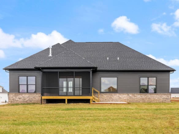 House with black exterior siding and a small wooden deck.