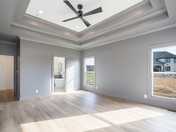 Bright, spacious living room with tray ceiling and large windows.