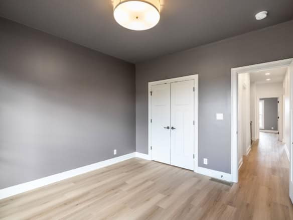 Bright, empty room with gray walls and light wood flooring at 7395 Edith Way.