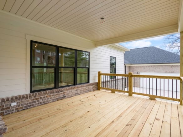 Freshly built wooden deck with railing at 7517 Beechspring Farm Blvd, showcasing new construction.