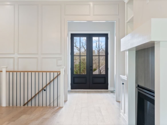 Bright and welcoming entryway with black door and white walls.